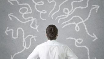 Mann vor einer Wand voller unterschiedlicher Wege - Karrierecoach - passendes Studium