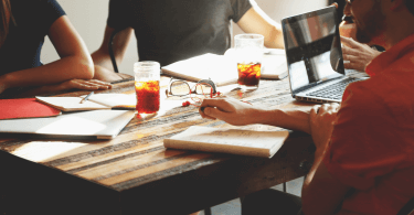 Arbeitnehmer sitzen zusammen am Tisch und arbeiten gemeinsam