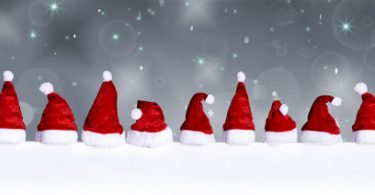 Viele Weihnachtsmützen auf einer schneebedeckten Fläche