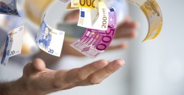 500 und 100€ Scheine, die in eine offene Hand fallen - Gehaltsreport