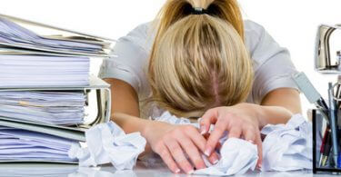 Frau zwischen Aktenbergen - Arbeit überstehen