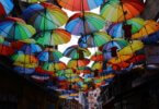 Versicherung Berufseinsteiger Straße mit bunten Regenschirmen