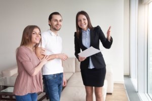 Maklerin mit Kunden bei Wohnungsbesichtigung