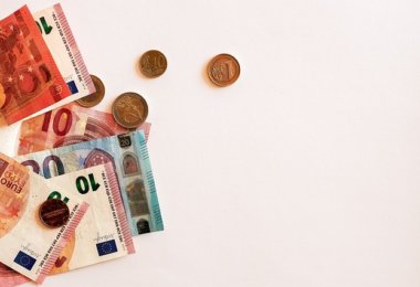 Euroscheine und Münzen auf weißem Hintergrund